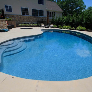 Kidney shaped in-ground salt water pool with outdoor kitchen