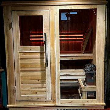A finished indoor sauna installed and powered in a home gym