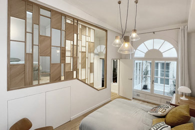 Modelo de dormitorio blanco y madera nórdico con paredes blancas, suelo de madera clara y boiserie