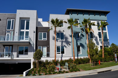 他の地域にあるビーチスタイルのおしゃれなグレーの家 (漆喰サイディング、アパート・マンション) の写真
