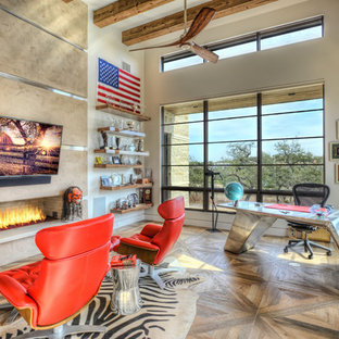 Inspiration for a large modern study in Houston with grey walls, ceramic flooring, a standard fireplace, a plastered fireplace surround, a freestanding desk and brown floors.