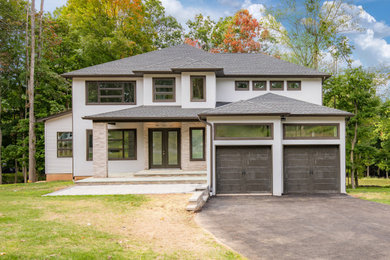 Modelo de fachada de casa beige y gris contemporánea de tamaño medio de dos plantas