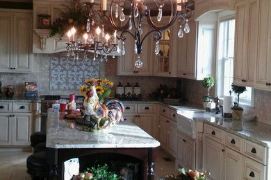 Eat-in kitchen - large traditional l-shaped porcelain tile eat-in kitchen idea in Chicago with a farmhouse sink, raised-panel cabinets, beige cabinets, marble countertops, multicolored backsplash, mosaic tile backsplash and an island