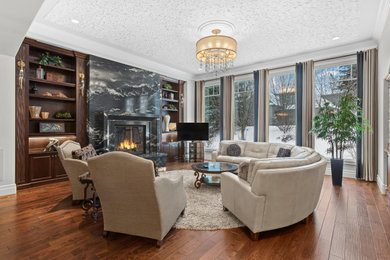 Large elegant formal and open concept dark wood floor, brown floor and tray ceiling living room photo in Edmonton with white walls, a ribbon fireplace, a stone fireplace and a tv stand