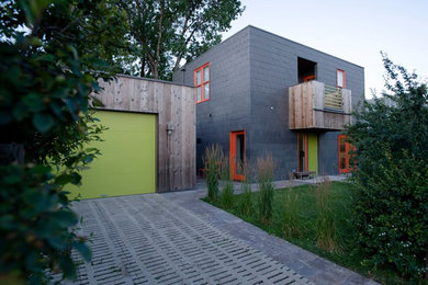 Small modern two-storey grey house exterior in Other with metal siding and a flat roof.