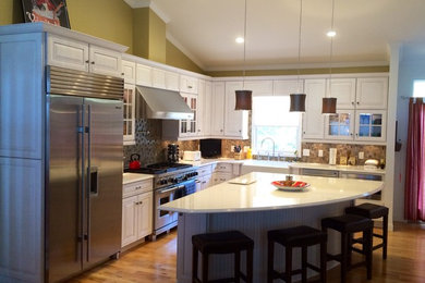 Inspiration for a mid-sized transitional l-shaped light wood floor open concept kitchen remodel in Grand Rapids with a farmhouse sink, raised-panel cabinets, white cabinets, quartzite countertops, multicolored backsplash, stainless steel appliances and an island