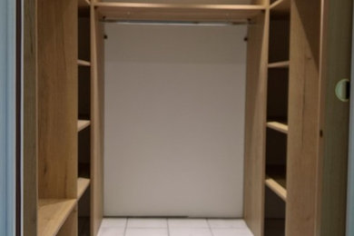 Aménagement d'un grand dressing room classique en bois clair neutre avec un placard sans porte, un sol en carrelage de céramique et un sol blanc.