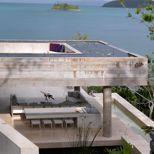 タウンズビルの巨大なインダストリアルスタイルのLDKの画像 (グレーの壁、コンクリートの床、暖炉なし、ベージュの床)