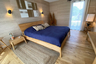 Exemple d'une chambre parentale tendance de taille moyenne avec un mur beige, parquet clair, un sol beige et du papier peint.