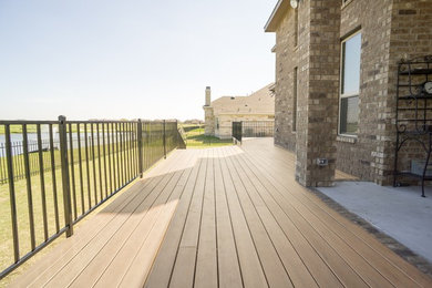Deck - large contemporary backyard deck idea in Austin with a roof extension