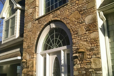 Example of a large classic beige two-story mixed siding gable roof design in Boston