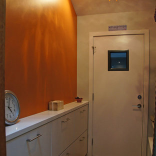 Idee per un ingresso o corridoio design di medie dimensioni con pareti arancioni, parquet chiaro e pavimento marrone