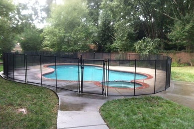 Inspiration for a mid-sized backyard custom-shaped lap pool in Charlotte with stamped concrete.
