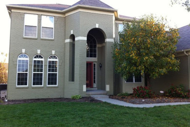 Large elegant green two-story brick exterior home photo in Indianapolis