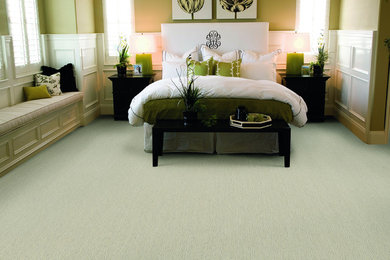 Example of a large transitional master carpeted bedroom design with green walls