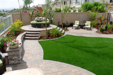 This is an example of a large traditional full sun and drought-tolerant backyard brick retaining wall landscape in Orange County.