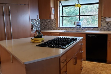 Mid-sized transitional u-shaped eat-in kitchen in Portland with a double-bowl sink, flat-panel cabinets, light wood cabinets, quartzite benchtops, multi-coloured splashback, glass tile splashback, panelled appliances, laminate floors, with island, beige benchtop and beige floor.