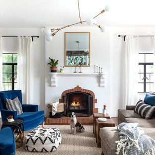 Mediterranes Wohnzimmer mit weißer Wandfarbe, braunem Holzboden, Kamin, Kaminsims aus Backstein und braunem Boden in Sacramento