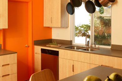This is an example of a mid-sized contemporary u-shaped eat-in kitchen in Los Angeles with a double-bowl sink, flat-panel cabinets, light wood cabinets, stainless steel appliances, ceramic floors, a peninsula, orange floor, quartz benchtops, grey splashback and grey benchtop.