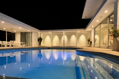 Large courtyard concrete and kidney-shaped natural hot tub photo in Los Angeles