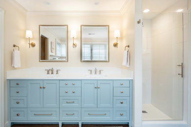Example of a classic master white tile and porcelain tile dark wood floor and double-sink alcove shower design in Kansas City with shaker cabinets, blue cabinets, an undermount sink, quartz countertops, a hinged shower door, white countertops and a built-in vanity