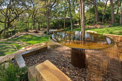 This is an example of a large traditional shade front yard stone landscaping in Austin for spring.