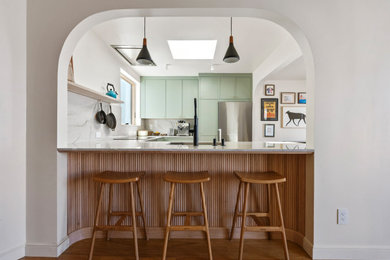 Inspiration for a mid-sized modern u-shaped medium tone wood floor eat-in kitchen remodel in San Francisco with flat-panel cabinets, green cabinets, marble countertops and white countertops