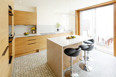Photo of a large contemporary kitchen in Edinburgh with flat-panel cabinets, medium wood cabinets and an island.