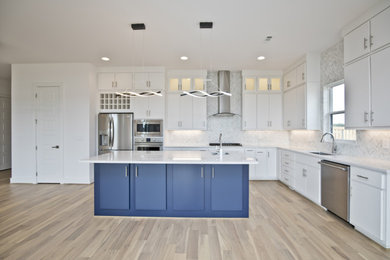 Example of a large trendy u-shaped light wood floor and beige floor eat-in kitchen design in Other with an undermount sink, flat-panel cabinets, white cabinets, quartz countertops, white backsplash, marble backsplash, stainless steel appliances, an island and white countertops