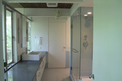 Corner shower - modern master porcelain tile and blue tile porcelain tile corner shower idea in Philadelphia with a vessel sink, flat-panel cabinets, white cabinets, white walls and quartzite countertops