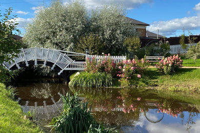 Пример оригинального дизайна: осенний сад с прудом в скандинавском стиле с с деревянным забором