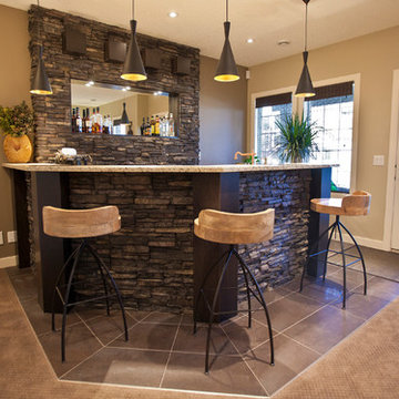 Stone basement wetbar and dark wood cabinetry