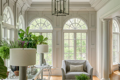 Inspiration for a large transitional medium tone wood floor and brown floor sunroom remodel in New York with a standard ceiling