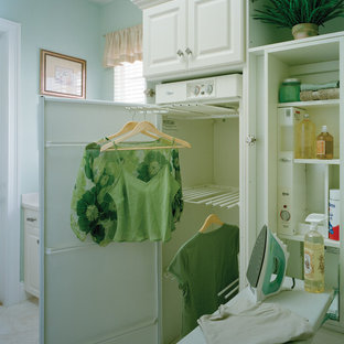 Photo of a traditional single-wall separated utility room in Miami with raised-panel cabinets, white cabinets, blue walls and ceramic flooring.