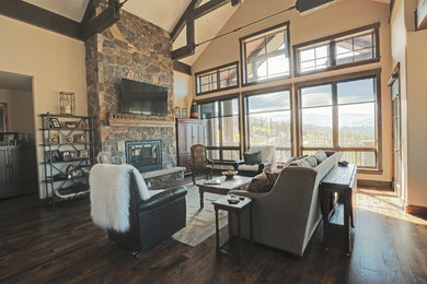 Large mountain style open concept dark wood floor and white floor living room photo in Denver with white walls, a standard fireplace, a stone fireplace and a wall-mounted tv