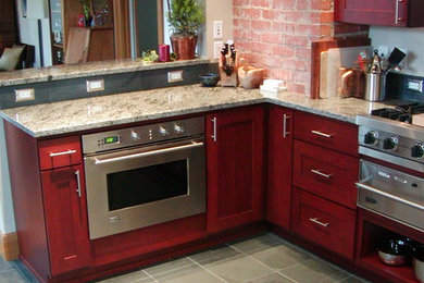 Example of a mid-sized trendy l-shaped ceramic tile enclosed kitchen design in Orange County with a double-bowl sink, recessed-panel cabinets, red cabinets, quartz countertops, gray backsplash, ceramic backsplash, stainless steel appliances and no island