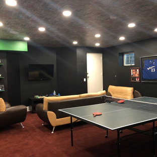 This is an example of a large contemporary look-out basement in New York with black walls, carpet and red floors.