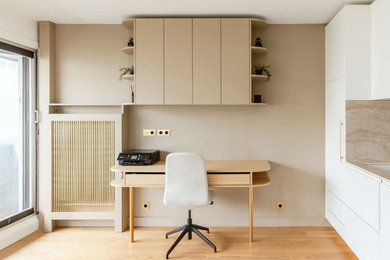 Cette photo montre un petit bureau tendance avec un mur beige, parquet clair, aucune cheminée, un bureau intégré et un sol beige.