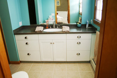 Example of a mid-sized classic kids' black tile ceramic tile bathroom design in New York with a drop-in sink, recessed-panel cabinets, white cabinets and blue walls