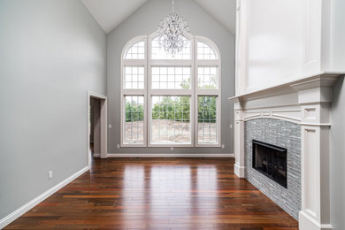 Example of a classic medium tone wood floor family room design in Other with green walls, a standard fireplace and a tile fireplace