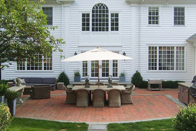 Patio kitchen - huge mediterranean backyard brick patio kitchen idea in New York