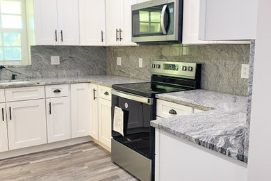 Inspiration for a mid-sized coastal u-shaped vinyl floor, gray floor and tray ceiling eat-in kitchen remodel in Miami with an undermount sink, shaker cabinets, white cabinets, granite countertops, multicolored backsplash, granite backsplash, stainless steel appliances, no island and multicolored countertops