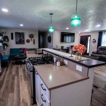 White Kitchen with Blue Tiled Backsplash and Two Tier Island