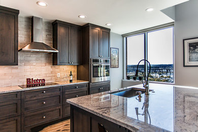 Inspiration for a mid-sized industrial l-shaped medium tone wood floor open concept kitchen remodel in Richmond with a farmhouse sink, beige backsplash, stone tile backsplash, stainless steel appliances and an island