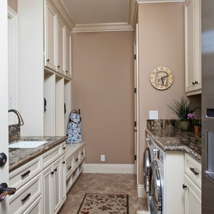 Photo of a medium sized traditional galley utility room in San Francisco with a submerged sink, recessed-panel cabinets, glass worktops, brown walls, a side by side washer and dryer and beige cabinets.