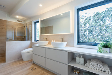 Mid-sized contemporary master bathroom in Sydney with flat-panel cabinets, beige cabinets, an open shower, a bidet, beige tile, porcelain tile, white walls, porcelain floors, a vessel sink, brown floor, an open shower, white benchtops, a single vanity and a freestanding vanity.