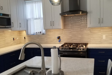 Mid-sized transitional l-shaped laminate floor and white floor enclosed kitchen photo in Other with an undermount sink, shaker cabinets, blue cabinets, quartz countertops, gray backsplash, porcelain backsplash, stainless steel appliances, an island and white countertops