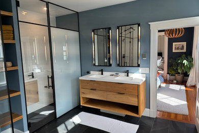 Example of a large trendy white tile and subway tile ceramic tile, black floor and double-sink bathroom design in Boston with furniture-like cabinets, light wood cabinets, a wall-mount toilet, multicolored walls, an undermount sink, quartz countertops, a hinged shower door, white countertops and a floating vanity