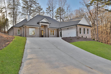 Inspiration for a mid-sized one-story brick house exterior remodel in Atlanta with a shingle roof and a black roof