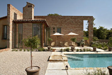 Inspiration for a mid-sized country rectangular pool in Bologna with a water feature and natural stone pavers.
